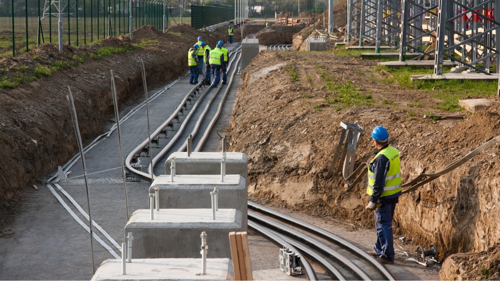 Brugg Cables crew installing high voltage underground cables in cable trench with concrete supports