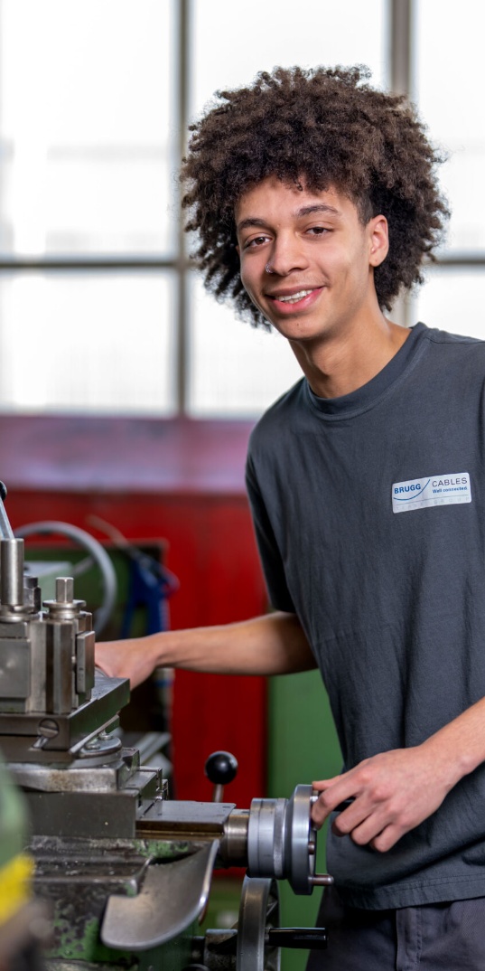 Brugg Cables technician working with industrial machinery in a production environment