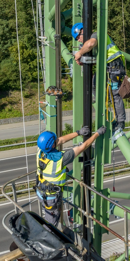 Brugg Cables tower installation work on high‑voltage structure above highway